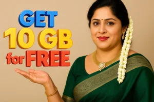 A woman with dark hair pulled over her left shoulder is shown from the chest up, looking directly at the viewer with a neutral expression. A long string of white flowers is draped over her left ear and cascades down to her shoulder. She is wearing a lime green or olive green saree with a golden patterned border along the pallu and the short sleeves of her blouse. She has a red bindi on her forehead, a gold chain, and a gold bracelet on her right wrist. Her right hand is near her stomach, and her left hand is resting on the dark surface she is leaning against. The background is a dark, plain wall.